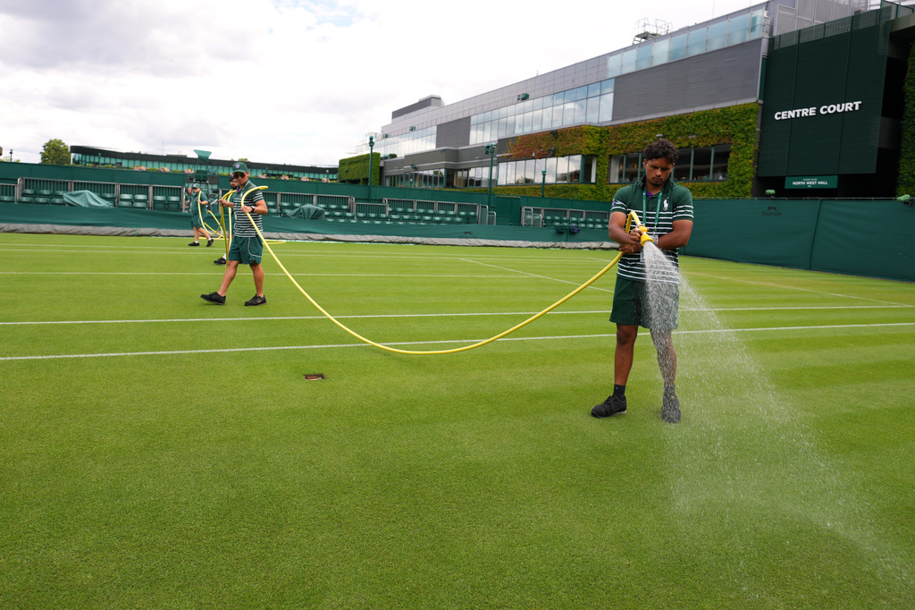 Ground staff waters a court one day ahead of the start of the Wimbledon Tennis Championships in London, Sunday, June 28, 2026.(AP Photo/Kirsty Wigglesworth)