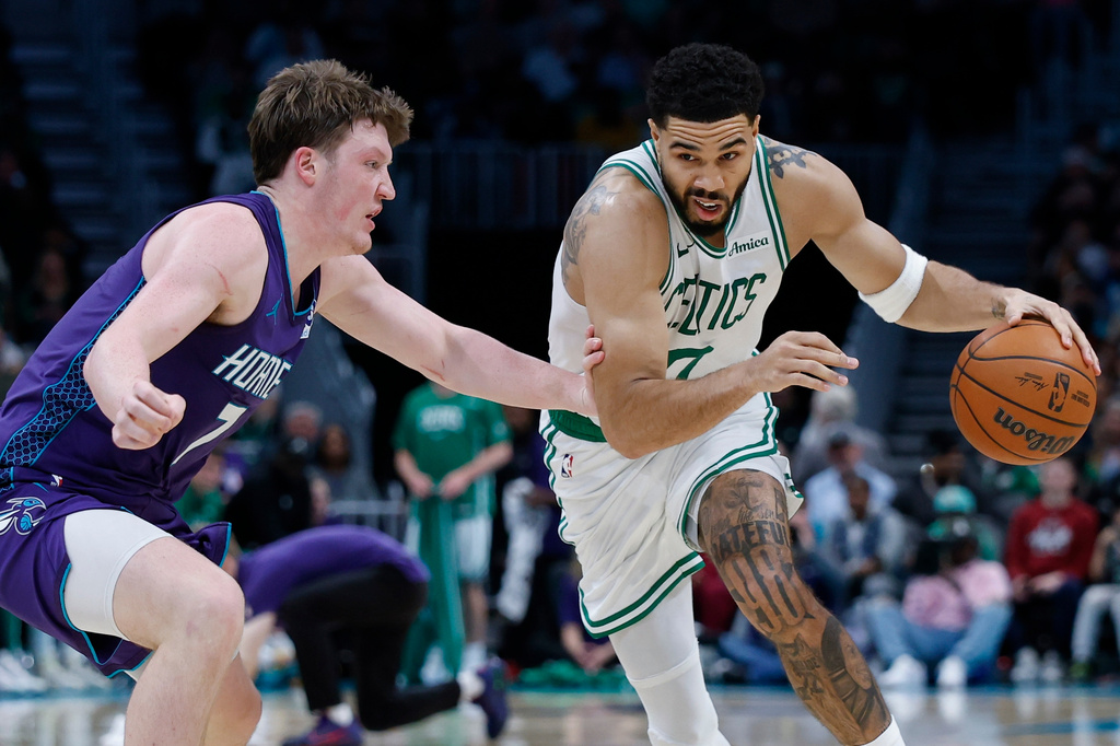 Boston Celtics forward Jayson Tatum, right, drives against Charlotte Hornets guard Kon Knueppel during the second half of an NBA basketball game in Charlotte, N.C., Sunday, March 29, 2026. (AP Photo/Nell Redmond)