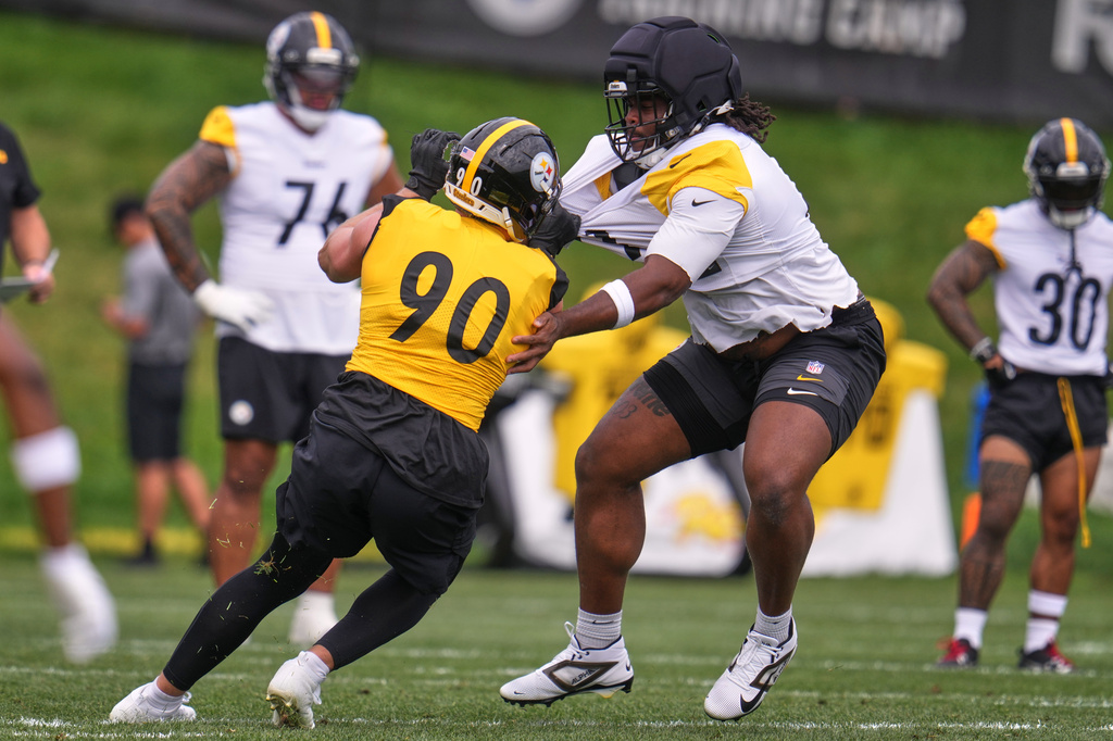 Pittsburgh Steelers offensive tackle Max Iheanachor, right, attempts to block linebacker T.J. Watt (90) during the NFL team's camp in Latrobe, Pa., Saturday, Aug. 1, 2026. (AP Photo/Gene J. Puskar)