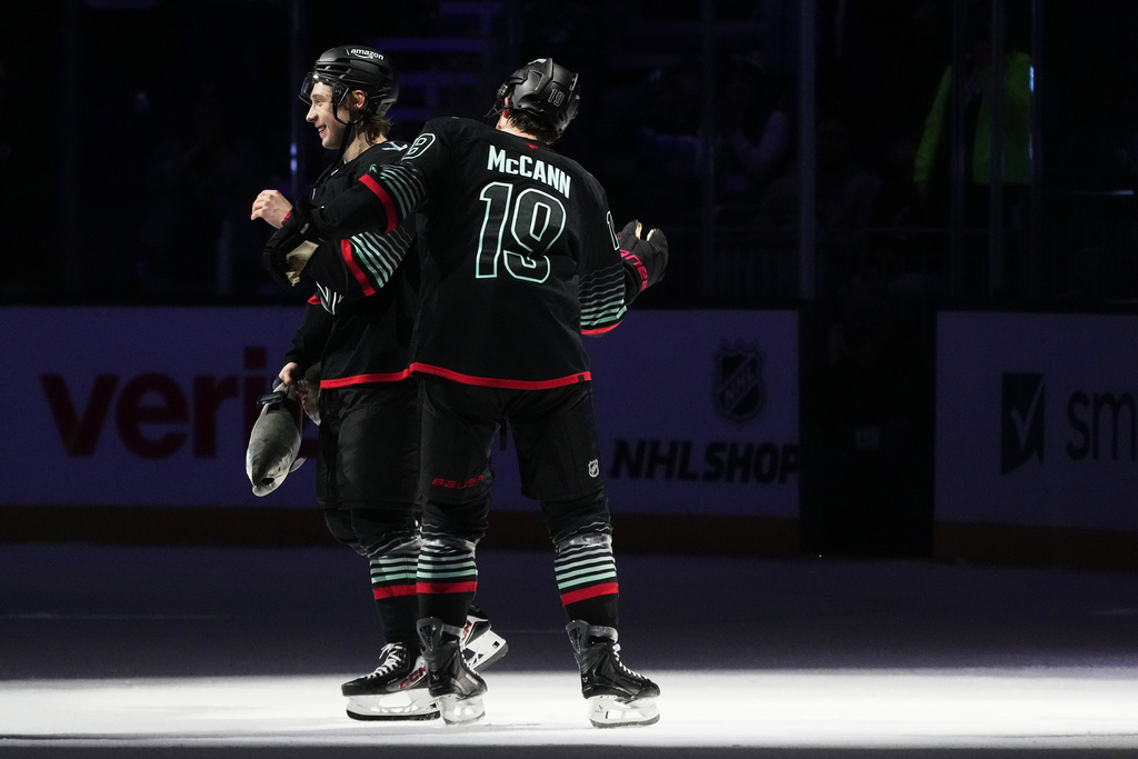 Seattle Kraken left wing Jared McCann (19) greets center Berkly Catton, left, as they celebrate after a win over the Boston Bruins in an NHL hockey game Tuesday, Jan. 6, 2026, in Seattle. (AP Photo/Lindsey Wasson)