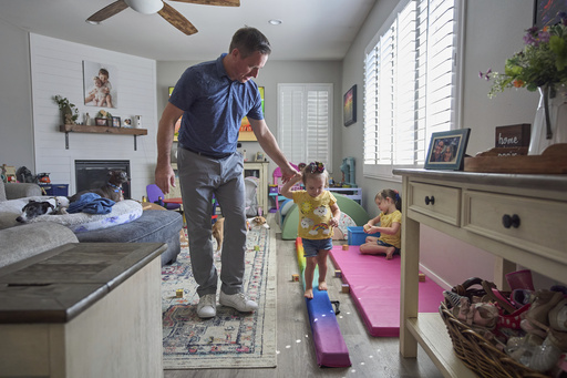 Josh Marris holds the hand of his daughter, Brooklyn Marris, as she walks on a balance board as her sister, Alana, right, plays at their home in Winchester, Calif., on Thursday, Sept. 18, 2025. (AP Photo/Gregory Bull) Josh Marris holds the hand of his daughter, Brooklyn Marris, as she walks on a balance board as her sister, Alana, right, plays at their home in Winchester, Calif., on Thursday, Sept. 18, 2025. (AP Photo/Gregory Bull)