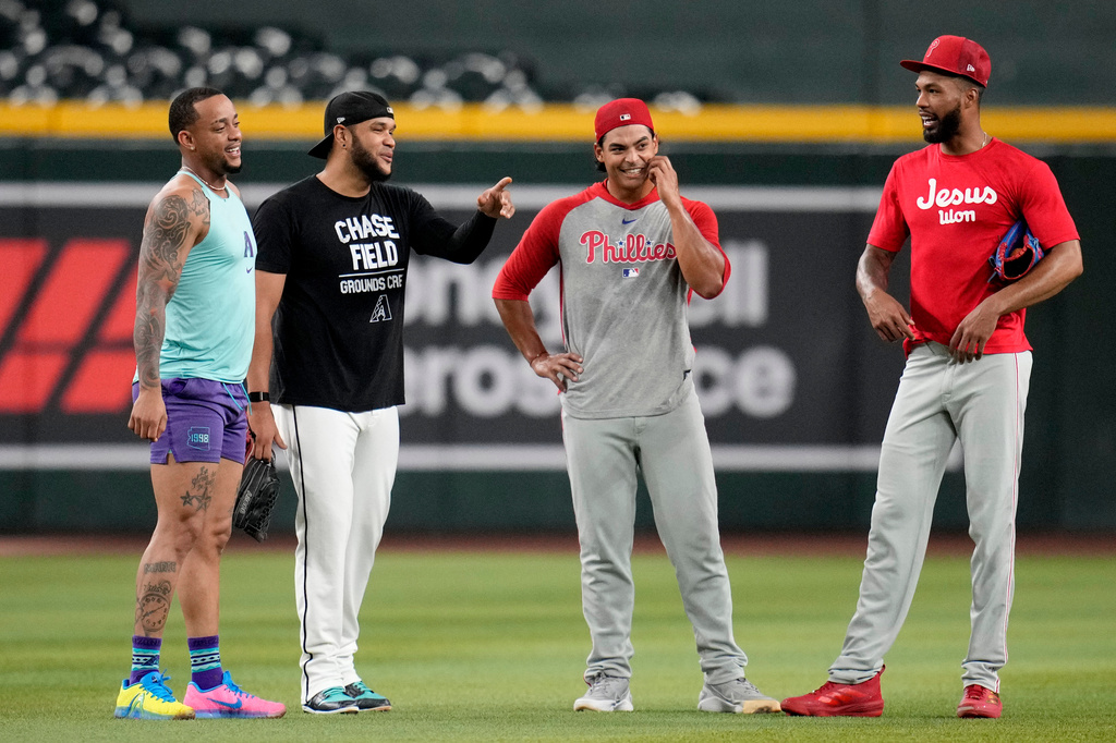 Returning Arizona Diamondbacks' Ketel Marte, left, talks with Diamondbacks' Eduardo Rodriguez, second from left, along with Philadelphia Phillies' Jesús Luzardo and Cristopher Sánchez, right, prior to a baseball game, Monday, Aug. 31, 2026, in Phoenix. (AP Photo/Ross D. Franklin)