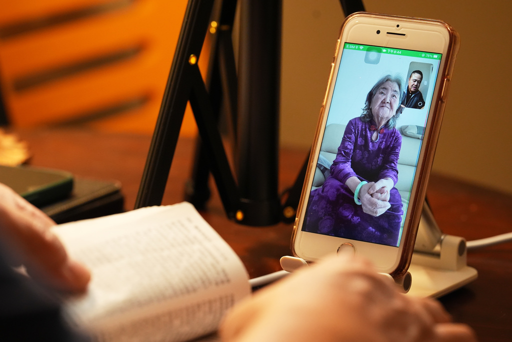Former Chinese official Li Chuanliang reads the Bible to his elderly mother Shen Shuzi back in China over a video call, in Midland, Texas, Jan. 18, 2025. (AP Photo/Rebecca Blackwell)