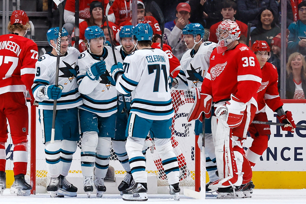 San Jose Sharks center Will Smith (2) celebrates with defenseman Dmitry Orlov (9), left wing Pavol Regenda (84) and center MacKlin Celebrini (71) after scoring against Detroit Red Wings goaltender John Gibson (36) during the first period of an NHL hockey game Friday, Jan. 16, 2026, in Detroit. (AP Photo/Duane Burleson)