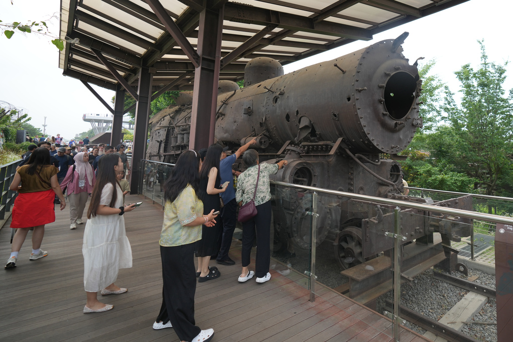 Tourists look at a steam train that was damaged during the Korean War, is displayed at the Imjingak Pavilion in Paju, South Korea, Saturday, July 4, 2026. (AP Photo/Lee Jin-man)