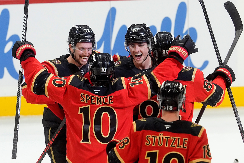 Ottawa Senators centre Shane Pinto (12)celebrates his game winning goal in a shootout with teammates centre Tim Stutzle (18), defenceman Jordan Spence (10) and defenceman Thomas Chabot (72) in NHL action against the Seattle Kraken in Ottawa, Thursday, Oct. 16, 2025. (Adrian Wyld/The Canadian Press via AP)