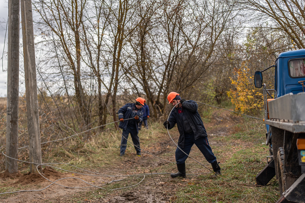 Workers repair power lines damaged in a Russian attack, Thursday, Oct. 16, 2025, in Shostka, Ukraine. (AP Photo/Julia Demaree Nikhinson)