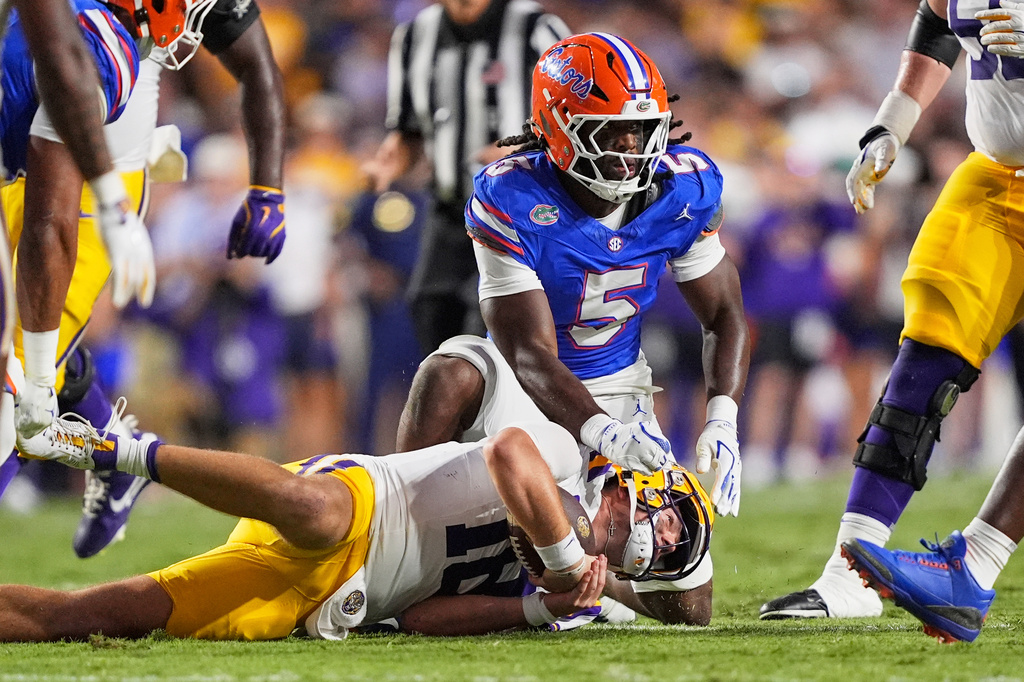 FILE - Florida linebacker Myles Graham (5) tackles LSU quarterback Garrett Nussmeier in the first half of an NCAA college football game, Sept. 13, 2025, in Baton Rouge, La. (AP Photo/Gerald Herbert, File)