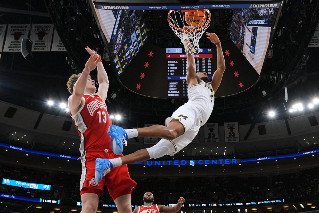 Michigan guard Nimari Burnett, right, drives to the basket past Ohio State center Christoph Tilly during the first half of an NCAA college basketball game in the quarterfinals of the Big 10 Conference tournament, Friday, March 13, 2026, in Chicago. (AP Photo/Nam Y. Huh)