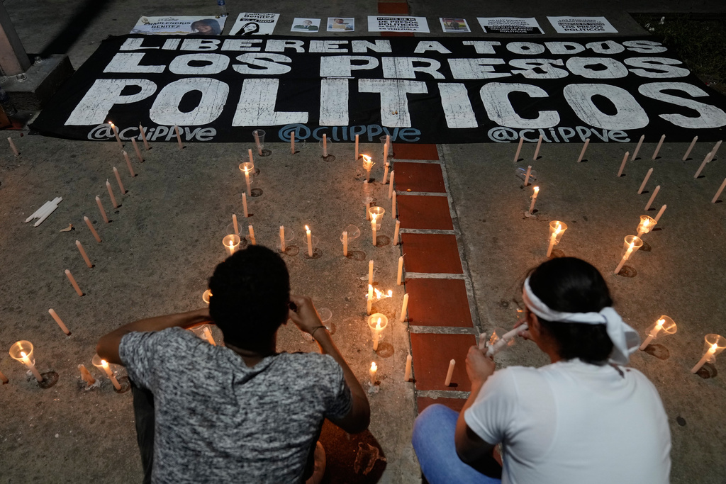 Relatives and friends of political prisoners light candles calling for their loved ones to be set free outside El Helicoide, the headquarters of Venezuela's intelligence service and detention center, in Caracas, Venezuela, Friday, Jan. 9, 2026 after the government announced prisoners would be released.(AP Photo/Ariana Cubillos)