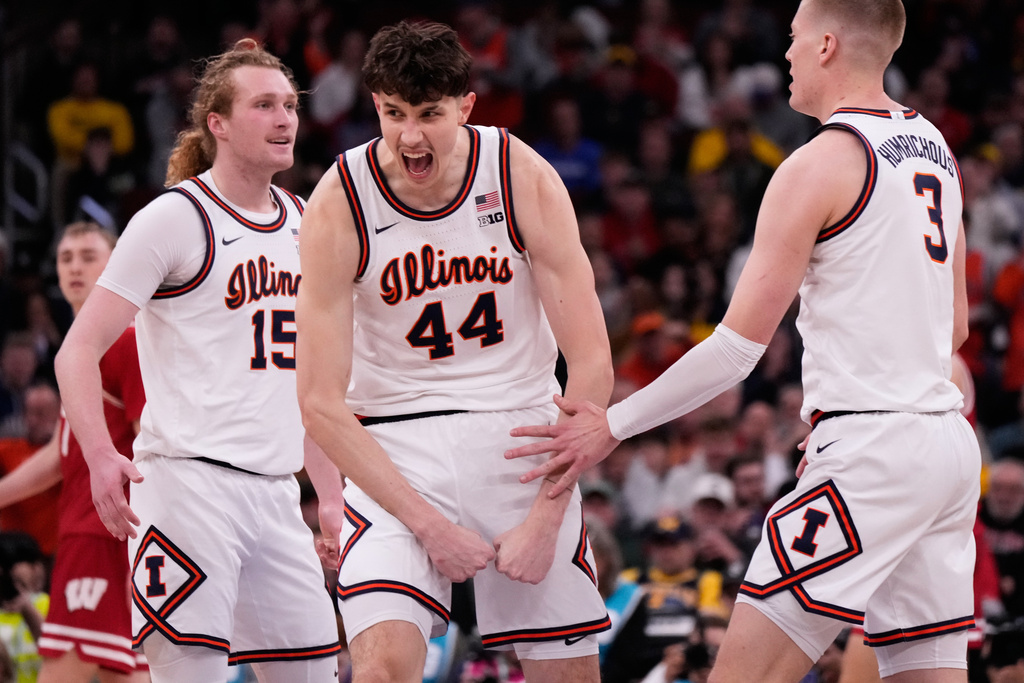 Illinois center Zvonimir Ivisic (44) celebrates with forwards Jake Davis, left, and\ Ben Humrichous after scoring a basket during the first half of an NCAA college basketball game against Wisconsin in the quarterfinals of the Big 10 Conference tournament, Friday, March 13, 2026, in Chicago. (AP Photo/Nam Y. Huh)