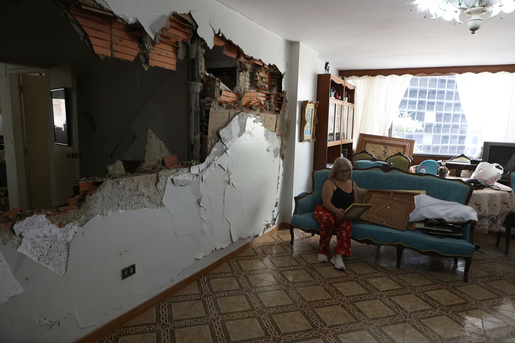 Ervia Ramírez sits in her damaged home two day after earthquakes struck Caracas, Venezuela, Friday, June 26, 2026. (AP Photo/Pedro Mattey)