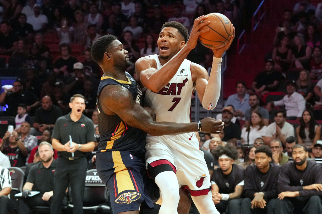 Miami Heat forward Giannis Antetokounmpo (7) looks to pass the ball under pressure from New Orleans Pelicans forward Zion Williamson (1) during the first half of an NBA preseason basketball game Thursday, Oct. 8, 2026, in Miami. (AP Photo/Marta Lavandier)