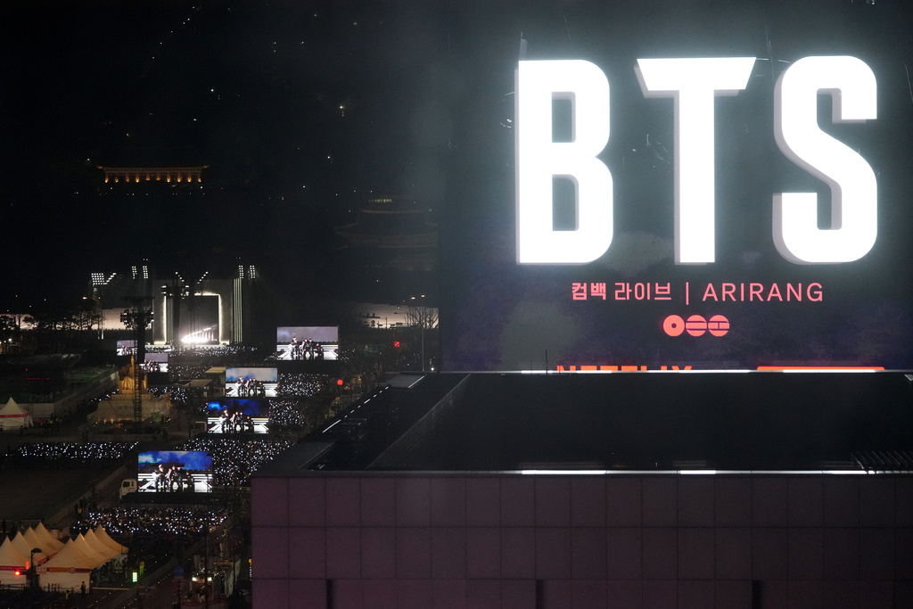 K-pop band BTS perform on the stage, left, during the comeback concert at Gwanghwamun Square in Seoul, South Korea, Saturday, March 21, 2026. (AP Photo/Lee Jin-man)