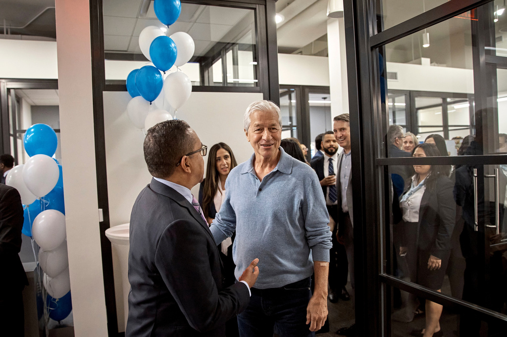 FILE - Jamie Dimon, CEO and chairman of JPMorgan Chase, center right, talks with an attendee during the community branch opening in the Bronx borough of New York, April 26, 2024. (AP Photo/Andres Kudacki, File)
