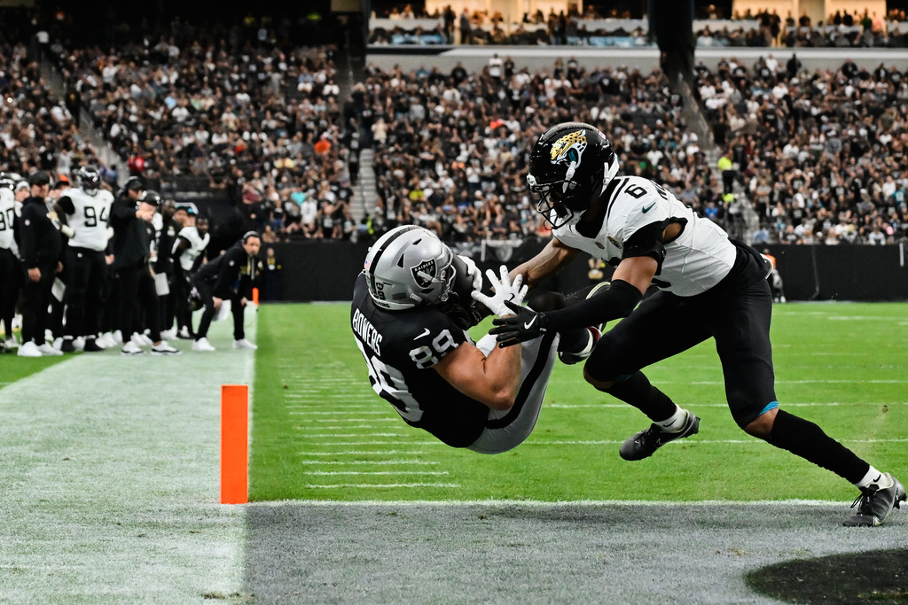 Las Vegas Raiders tight end Brock Bowers (89) catches a touchdown while defended by Jacksonville Jaguars cornerback Greg Newsome II (6) during the first half of an NFL football game, Sunday, Nov. 2, 2025, in Las Vegas. (AP Photo/David Becker)