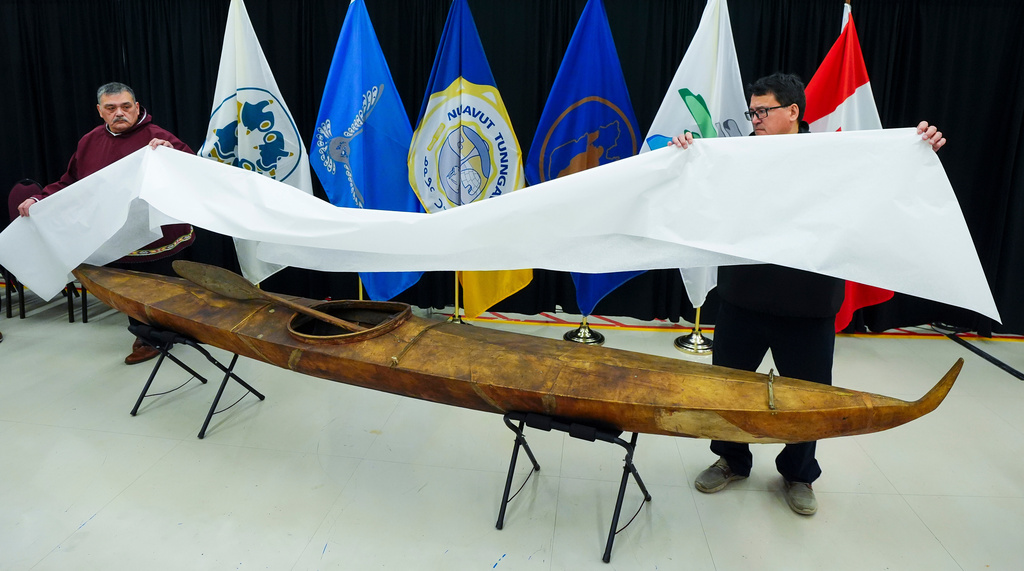 Darrel Nasogaluak, Elder and Chair of Tuktoyaktuk Community Corp., left, and Duane Smith, Chair and CEO of the Inuvialuit Regional Corp., unveil a traditionally built Inuvialuit kayak at the Canadian Museum of History in Gatineau, Que., on Tuesday, Dec. 9, 2025. (Sean Kilpatrick /The Canadian Press via AP)