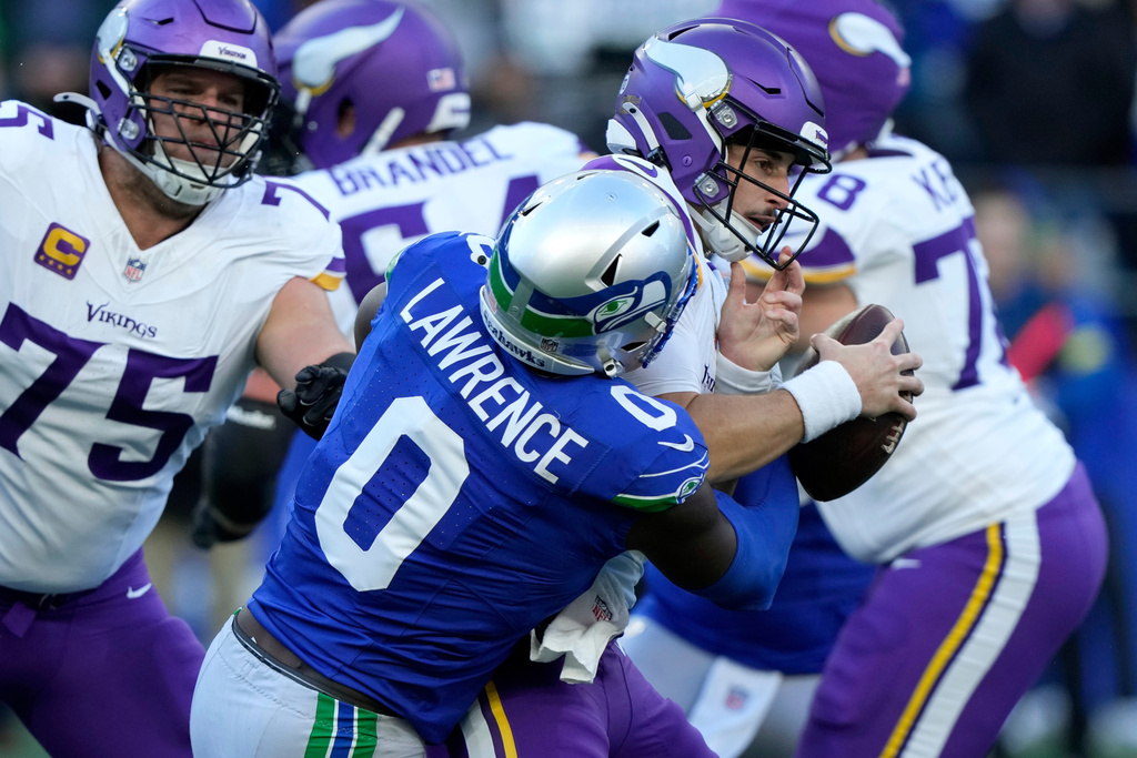 Seattle Seahawks defensive end DeMarcus Lawrence (0) sacks Minnesota Vikings quarterback Max Brosmer during the first half of an NFL football game, Sunday, Nov. 30, 2025, in Seattle. (AP Photo/Stephen Brashear)