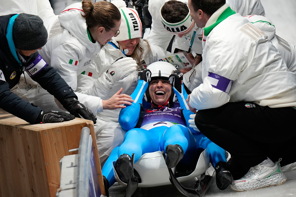Italy's gold medalists Andrea Voetter and Marion Oberhofer celebrate as they arrive at the finish during a women's doubles luge run at the 2026 Winter Olympics, in Cortina d'Ampezzo, Italy, Wednesday, Feb. 11, 2026. (AP Photo/Aijaz Rahi)