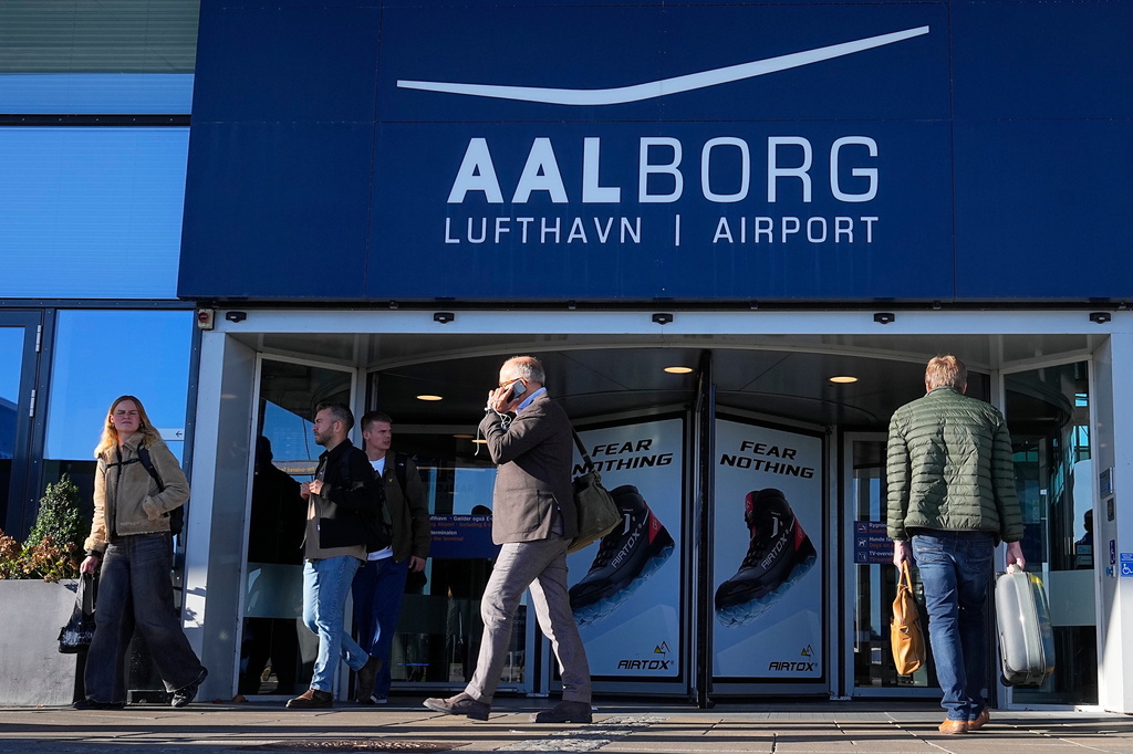 People walk outside Aalborg Airport in Denmark, Thursday, Sept. 25, 2025, after drones were observed on the airport on Wednesday evening and the night to Thursday, and the airspace over the airport was closed. (Bo Amstrup/Ritzau Scanpix via AP)
