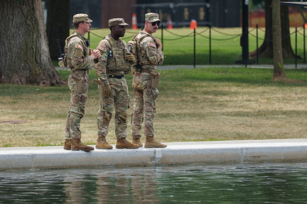 Members of the National Guard stop and look at the Lincoln Memorial Reflecting Pool Sunday, June 21, 2026, on the National Mall in Washington. (AP Photo/Jon Elswick