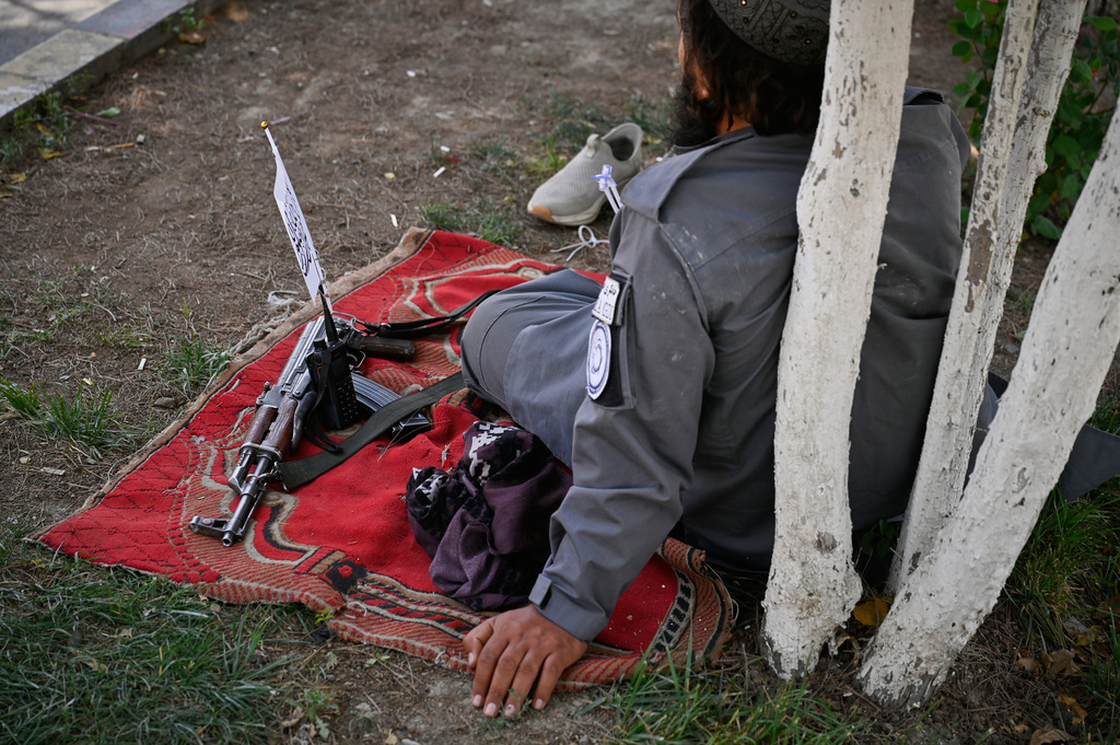 A Taliban policeman rests beside his rifle during celebrations marking the fifth anniversary of the U.S. withdrawal from Afghanistan and the Taliban's return to power, in Kabul, Afghanistan, Saturday, Aug. 15, 2026. (AP Photo/Nava Jamshidi)