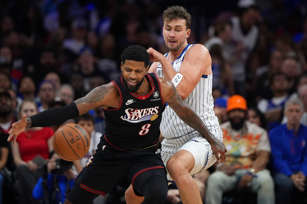 Philadelphia 76ers' Paul George, left, tries to get past Orlando Magic's Franz Wagner during the first half of an NBA play-in tournament basketball game Wednesday, April 15, 2026, in Philadelphia. (AP Photo/Matt Slocum)