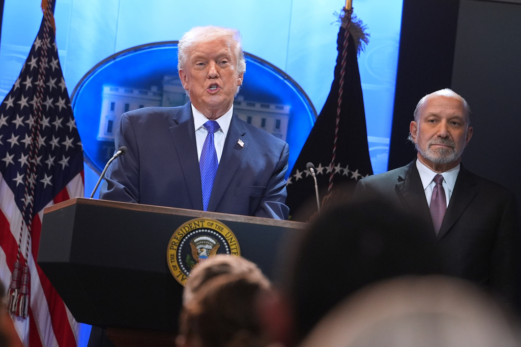 President Donald Trump speaks during a press briefing at the White House, Friday, Feb. 20, 2026, in Washington, as Commerce Secretary Howard Lutnik, looks on. (AP Photo/Evan Vucci)