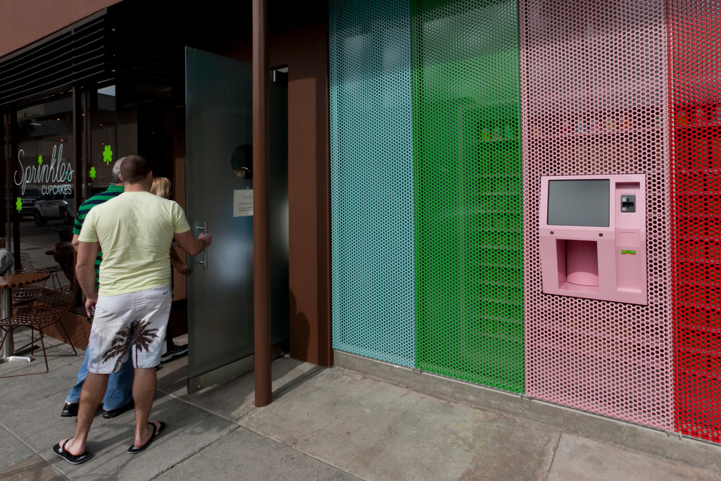 FILE - A newly-installed 24-Hour Cupcake "ATM," that will be continuously restocked to dispense fresh cupcakes, is seen right as patrons enter Sprinkles Cupcakes in Beverly Hills, Calif., March 5, 2012. (AP Photo/Damian Dovarganes, File)