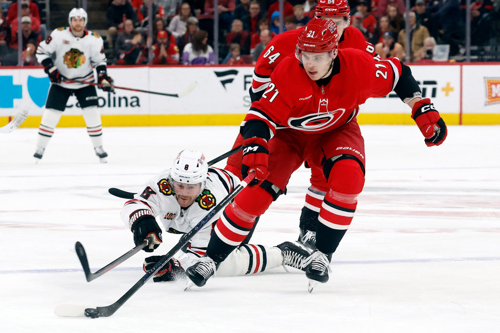 Carolina Hurricanes' Alexander Nikishin takes the puck away from Chicago Blackhawks' Ryan Donato (8) during the first period of an NHL hockey game in Raleigh, N.C., Thursday, Jan. 22, 2026. (AP Photo/Karl DeBlaker)