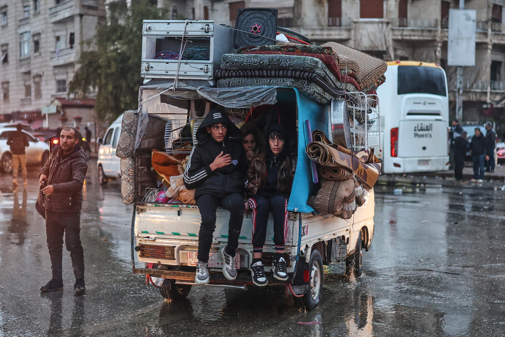 Residents flee the Sheikh Maqsoud neighborhood of Aleppo, Syria, Friday, Jan. 9, 2026, after the government declared the area a closed military zone following days of clashes between government forces and Kurdish fighters. (AP Photo/Ghaith Alsayed)