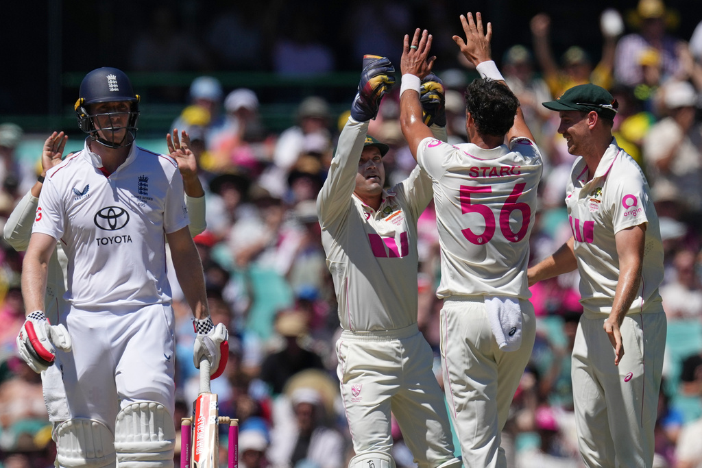 England's Zak Crawley, left, reacts after he was dismissed by Australia's Mitchell Starc, second right, during play on day four of the fifth and final Ashes cricket test between England and Australia in Sydney, Wednesday, Jan. 7, 2026. (AP Photo/Mark Baker)