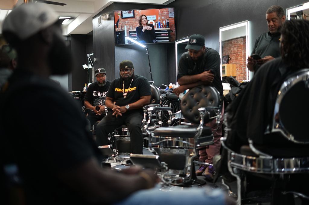 A video with former Vice President Kamala Harris plays in the background at Philly Cuts in Philadelphia, Friday, Aug. 21, 2026, during a discussion facilitated by Win With Black Men. (AP Photo/Matt Rourke)