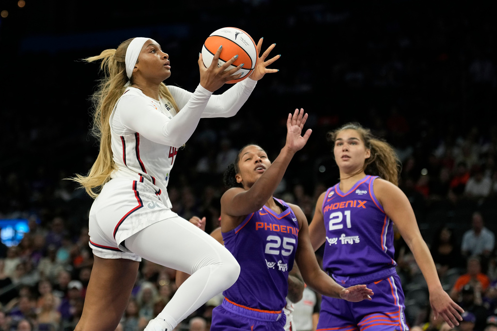 Washington Mystics forward Kiki Iriafen, left, drives past Phoenix Mercury forwards Alyssa Thomas (25) and Maddy Westbeld (21) during the second half of a WNBA basketball game, Thursday, Aug. 27, 2026, in Phoenix. (AP Photo/Ross D. Franklin)