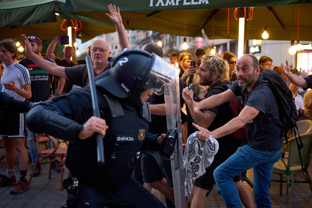 Police officers clash with protesters during a pro-Palestinian rally in solidarity with the Global Sumud Flotilla after ships were intercepted by the Israeli navy, in Barcelona, Spain, Saturday, Oct. 4, 2025. (AP Photo/Emilio Morenatti)