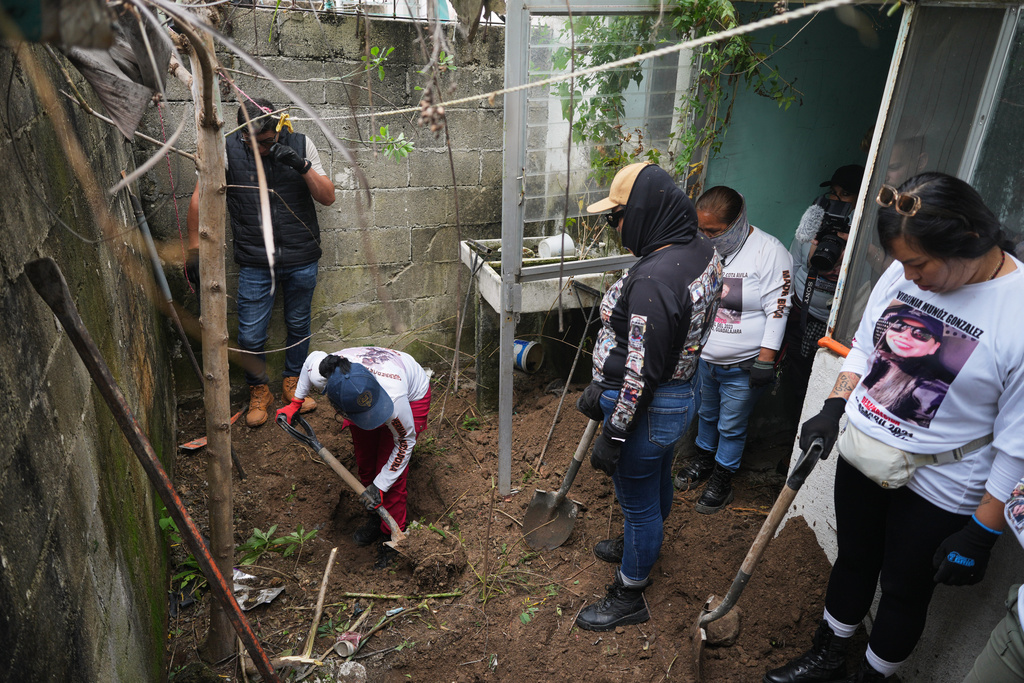 FILE - Relatives of missing people, part of a group called the Guerreros Buscadores, inspect an area where they suspect bodies may be buried, in the Valle de los Olivos neighborhood of Guadalajara, Mexico, Oct. 14, 2025. (AP Photo/Eduardo Verdugo, File)