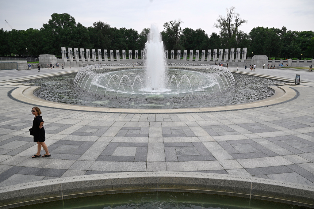 A visitor walks the WWII memorial the morning after it was vandalized, shown Friday, Aug. 14, 2026, in Washington. (AP Photo/John McDonnell)