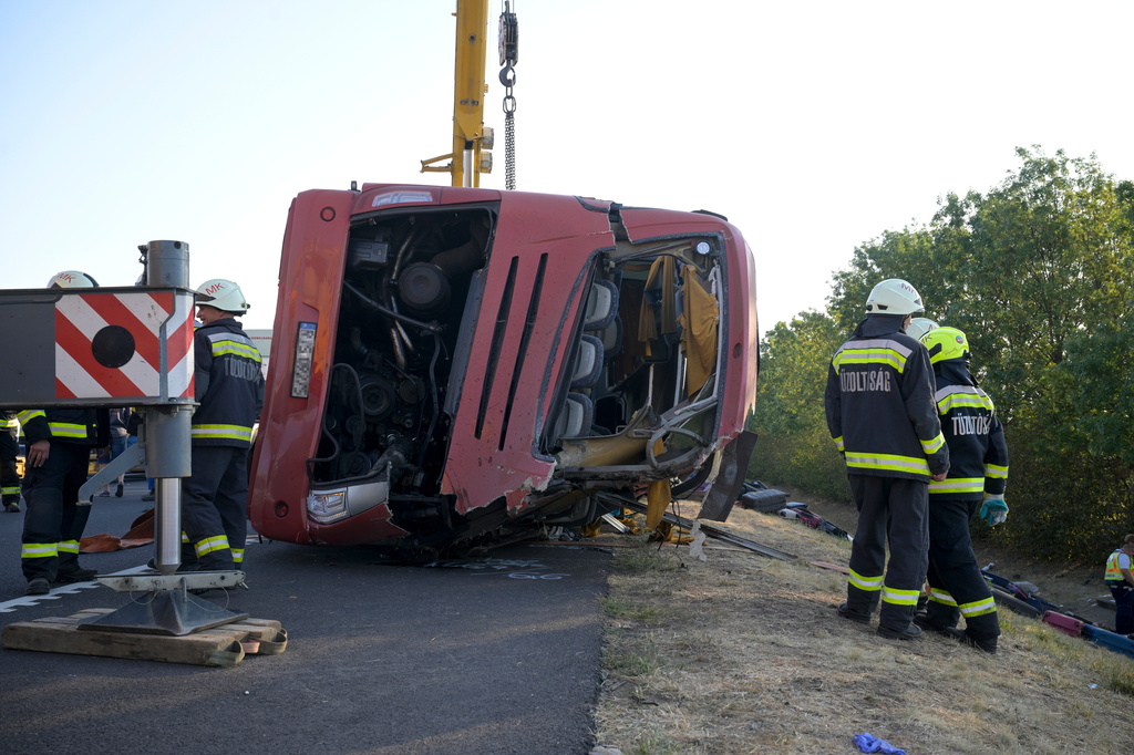 Emergency services attend the scene after a passenger bus went off the road and overturned in a ditch along a highway between Mezokeresztes and Mezonagymihaly in Hungary, Sunday, Aug. 16, 2026. (Zoltan Mathe/MTI via AP)