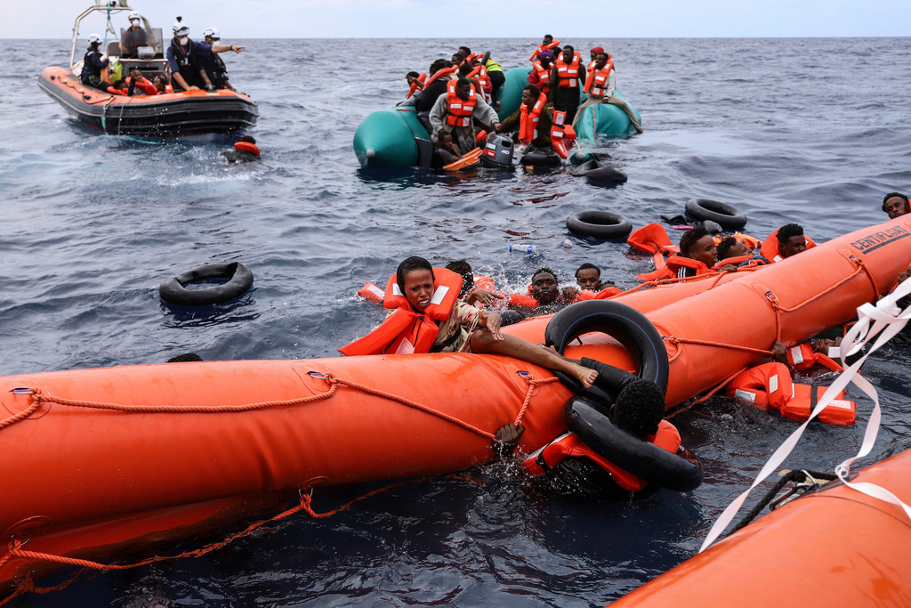 FILE - Migrants who fell in the water struggle to cling on to a a float before being rescued by a humanitarian rescuers, around 35 miles away from Libya, in the Mediterranean Sea, Oct. 18, 2021. (AP Photo/Valeria Mongelli, File) (AP Photo/Valeria Mongelli, File)