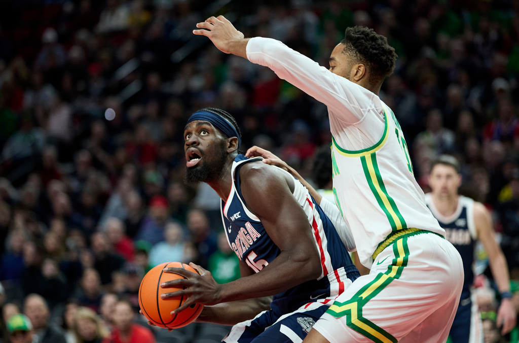 Gonzaga forward Graham Ike, left, looks to shoot in front of Oregon forward Kwame Evans Jr. during the first half of an NCAA college basketball game in Portland, Ore., Sunday, Dec. 21, 2025. (AP Photo/Craig Mitchelldyer)
