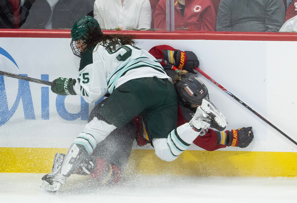 Boston Fleet defense Daniela Pejsova (55) sends Ottawa Charge forward Rebecca Leslie (37) into the boards during the first period of Game 4 in a PWHL hockey playoff series in Ottawa, Ontario, Sunday, May 10, 2026. (Adrian Wyld/The Canadian Press via AP)