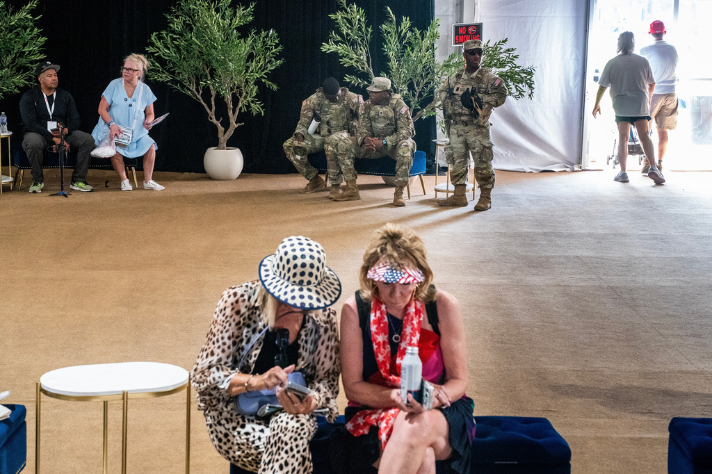 Visitors and members of the National Guard rest in the shade of a tent while attending the Great American State Fair on the National Mall, Wednesday, July 1, 2026, in Washington. (AP Photo/Nathan Howard)
