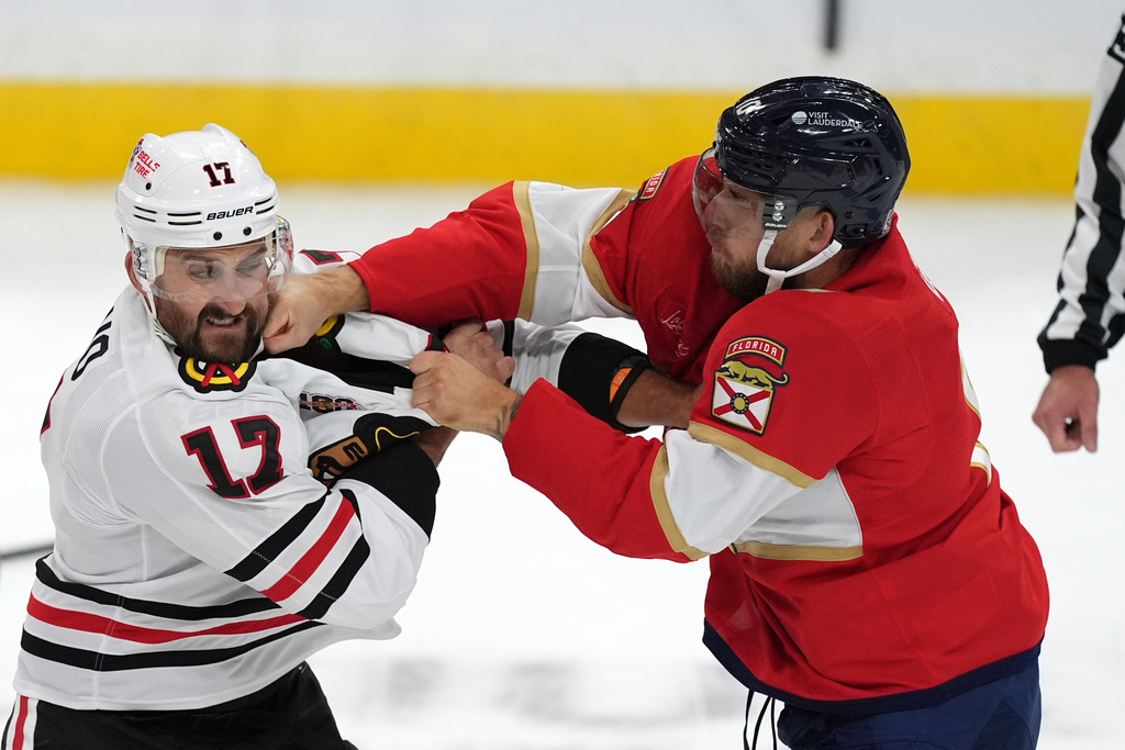 Chicago Blackhawks left wing Nick Foligno (17) and Florida Panthers left wing A.J. Greer fight during the first period of an NHL hockey game, Tuesday, Oct. 7, 2025, in Sunrise, Fla. (AP Photo/Rebecca Blackwell)