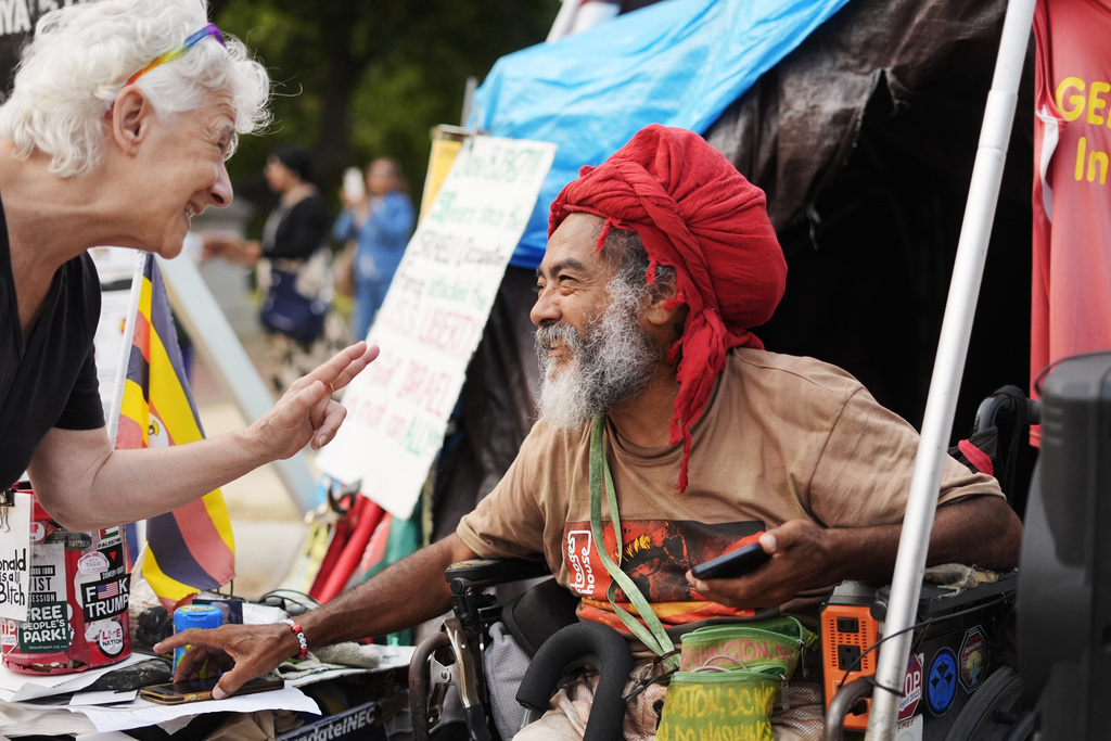Philipos Melaku-Bello smiles as he speaks to a passerby at the White House Peace Vigil in Lafayatte Park across the street from the White House in Washington, Friday, Sept. 5, 2025. (AP Photo/Pablo Martinez Monsivais)