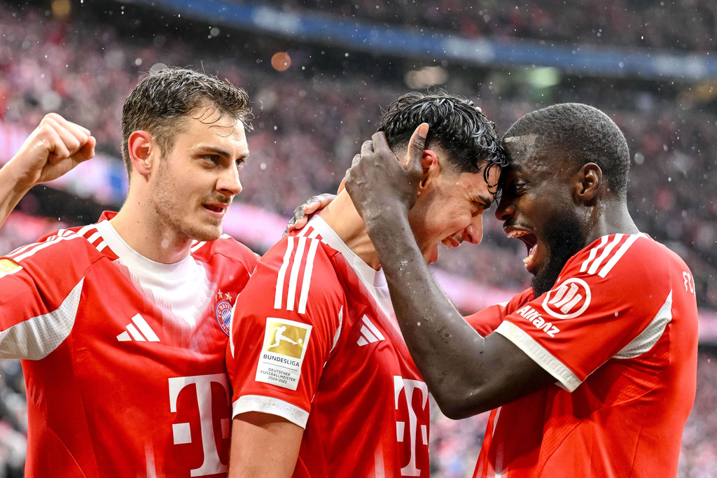 Bayern Munich's Aleksandar Pavlovic, center, celebrates scoring with Josip Stanisic, left, and Dayot Upamecano during the Bundesliga soccer match between Bayern Munich and Eintracht Frankfurt in Munich, Germany, Saturday Feb. 21, 2026. (Harry Langer/dpa via AP)