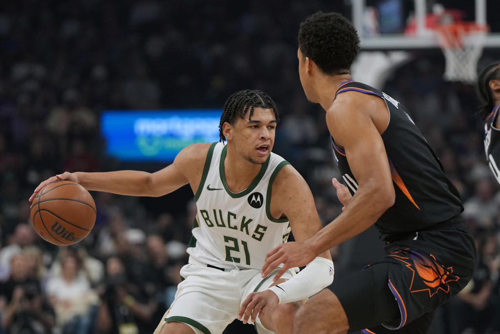 Milwaukee Bucks forward Ousmane Dieng (21) shields the ball from Phoenix Suns forward Oso Ighodaro during the first half of an NBA basketball game, Saturday, March 21, 2026, in Phoenix. (AP Photo/Rick Scuteri)