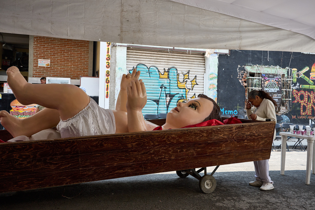 A parishioner crosses herself in front of a giant Baby Jesus in Mexico City, Tuesday, March 10, 2026. (AP Photo/Ginnette Riquelme)
