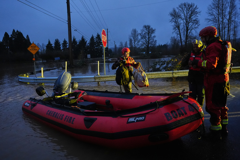 Chehalis Fire rescue workers help residents evacuate their flooded neighborhood after heavy rains in the region Tuesday, Dec. 9, 2025, in Chehalis, Wash. (AP Photo/Lindsey Wasson)