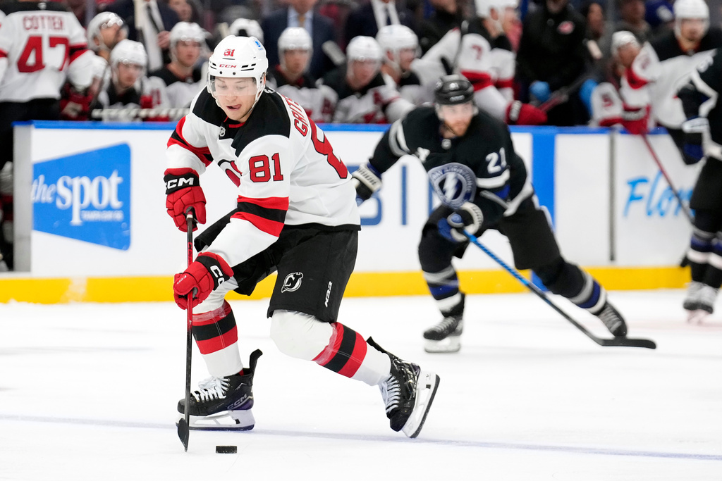 New Jersey Devils right wing Arseny Gritsyuk (81) breaks out ahead of Tampa Bay Lightning center Brayden Point (21) during the third period of an NHL hockey game Saturday, Oct. 11, 2025, in Tampa, Fla. (AP Photo/Chris O'Meara)