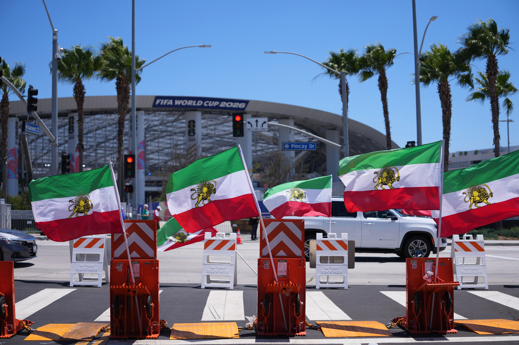 Pre-revolutionary Iranian flags stand during a protest outside Los Angeles Stadium before the World Cup Group G soccer match between Iran and New Zealand in Inglewood, Calif., near Los Angeles, Monday, June 15, 2026. (AP Photo/Jae C. Hong)